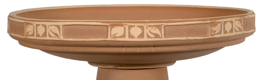 Terracotta-colored bird bath with decorative patterns on a white background