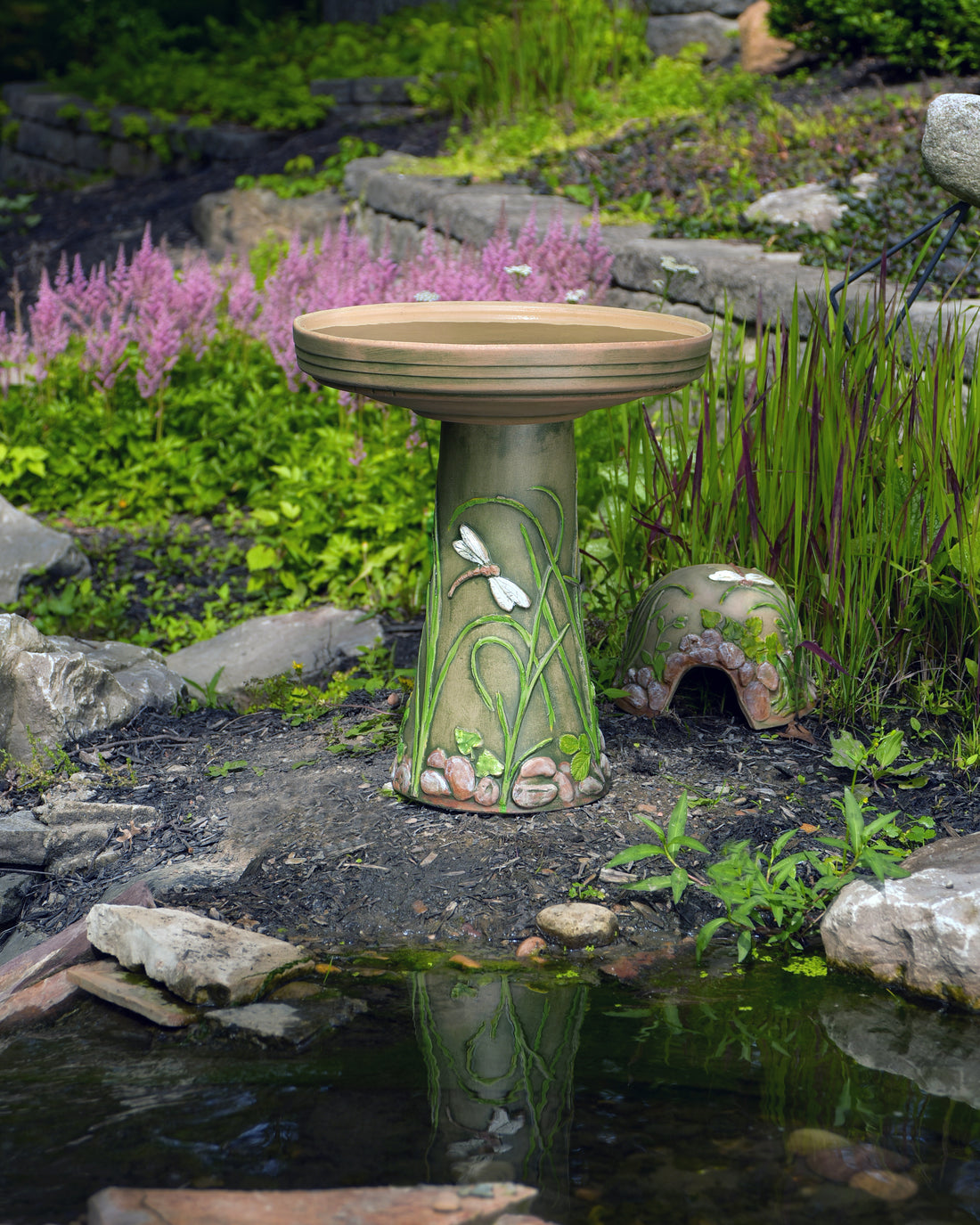 ceramic birdbath set with hand painted dragonfly and toad house in landscaped garden area
