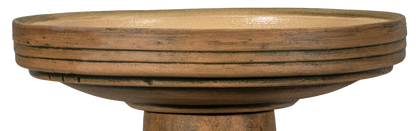 Decorative bird bath with natural elements on a white background