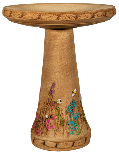 Decorative bird bath with floral and bee designs on a white background