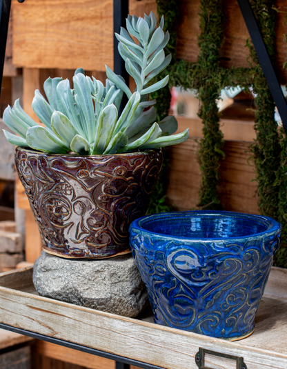 two small ceramic planters in purple and blue glaze with swirl design and succulents