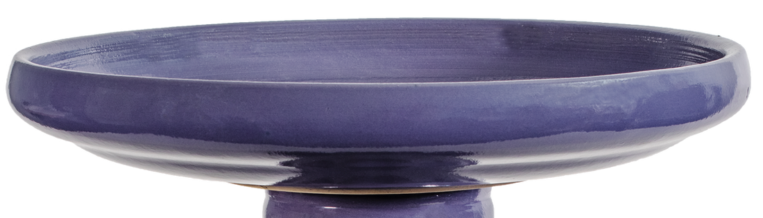 Purple ceramic bird bath on a white background