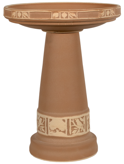 Terracotta-colored bird bath with decorative patterns on a white background