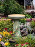 ceramic birdbath set with hand painted hummingbirds in landscaped garden area