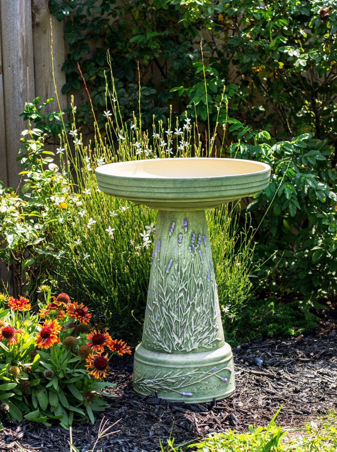 ceramic birdbath set with hand painted lavender in landscaped garden area