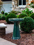 ceramic green birdbath with simple modern smooth design in a landscaped garden setting