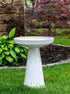 ceramic White birdbath with simple modern smooth design in a landscaped garden setting